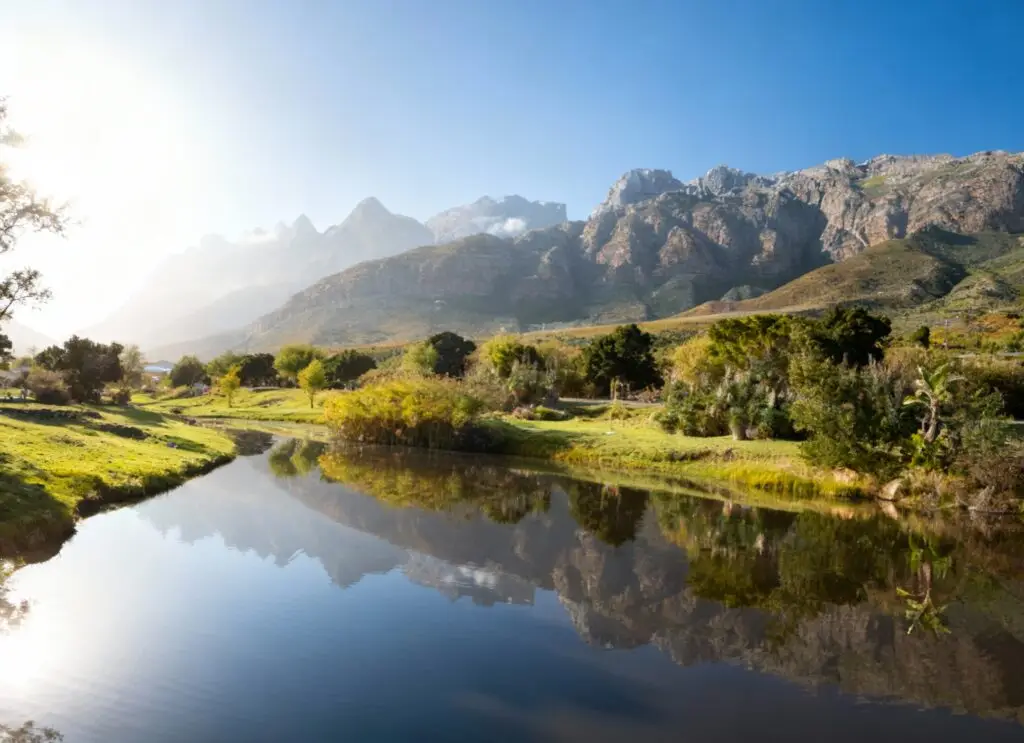 Scenic Breede River Valley with river, greenery, and towering mountain ranges